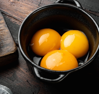 Bright yellow egg yolks set, on old dark  wooden table